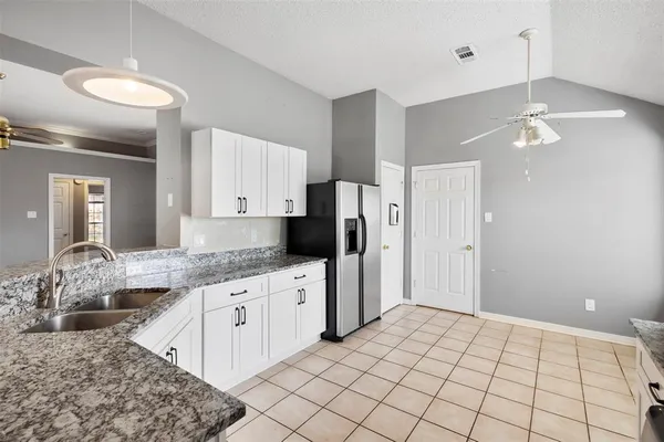 a large kitchen with a stove a sink dishwasher and a refrigerator with wooden floor