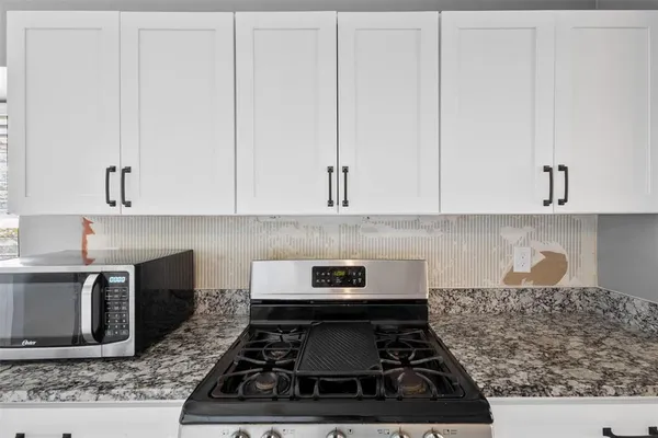 a kitchen with white cabinets and appliances