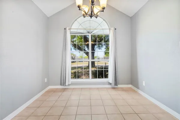 an empty room with windows and chandelier