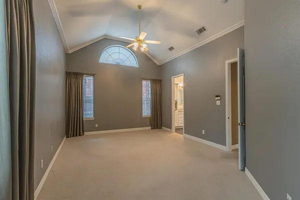 an empty room with fan and windows