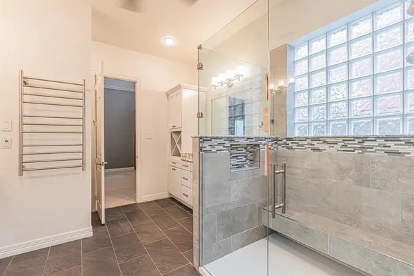 an empty room with a chandelier fan and windows