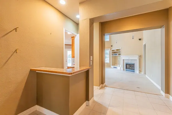 a view of an empty room with a fireplace and a window