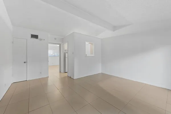 a view of an empty room with window and bathroom