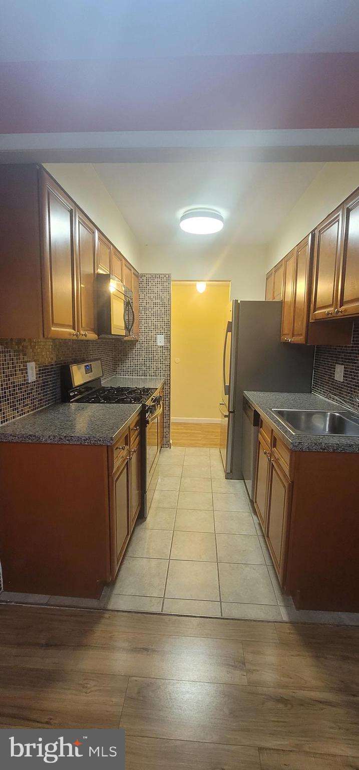a large kitchen with stainless steel appliances a large counter top and a stove