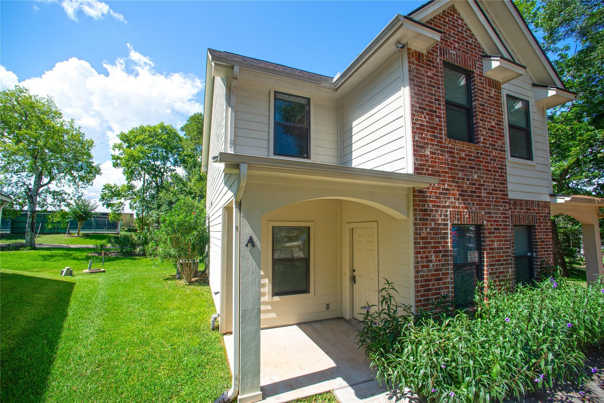 1426 April Villas, Unit A Conroe, TX 77356 - Photo 2 of 8 a front view of a house with garden