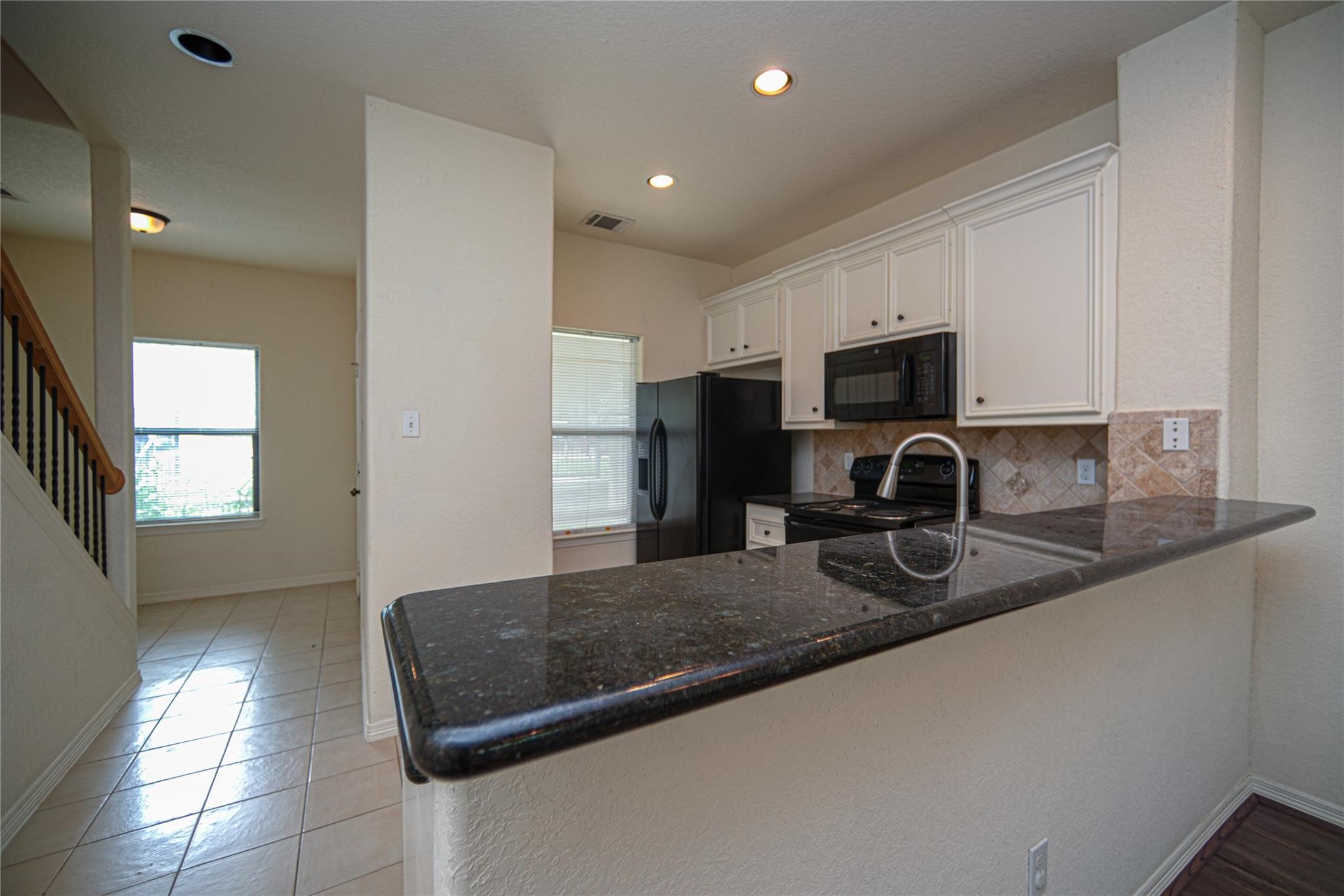 1426 April Villas, Unit A Conroe, TX 77356 - Photo 4 of 8 a kitchen with sink refrigerator and microwave