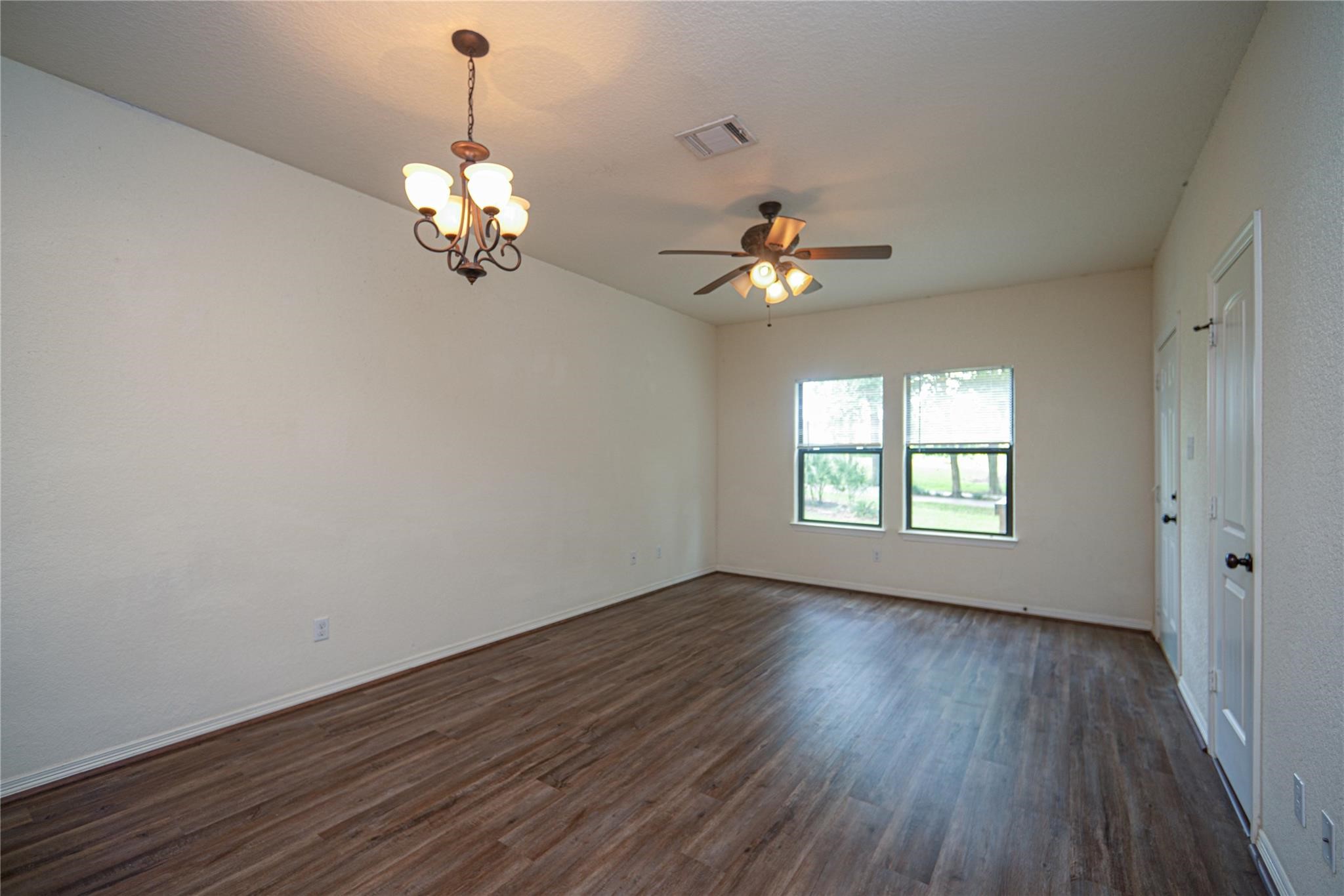 1426 April Villas, Unit A Conroe, TX 77356 - Photo 6 of 8 a view of an room with wooden floor and chandelier