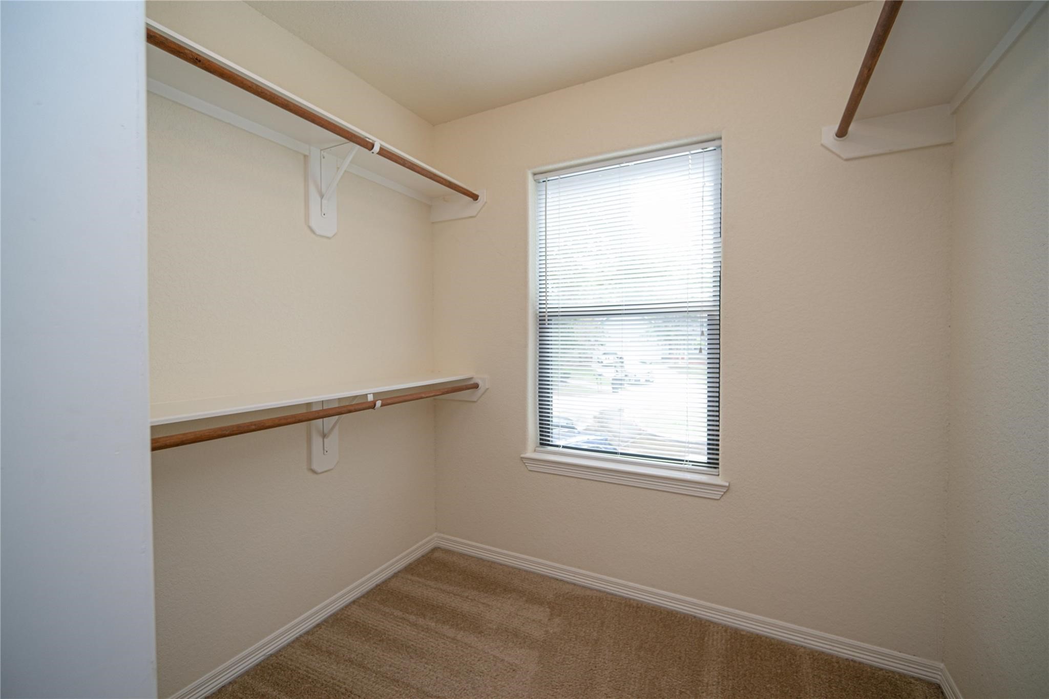 1426 April Villas, Unit A Conroe, TX 77356 - Photo 8 of 8 a view of a room with rack on the wall and a window