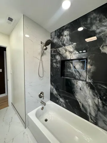 a bathroom with a bathtub and shower