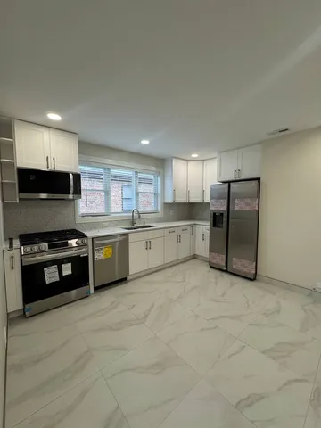 a large kitchen with stainless steel appliances granite countertop a stove a sink and a refrigerator