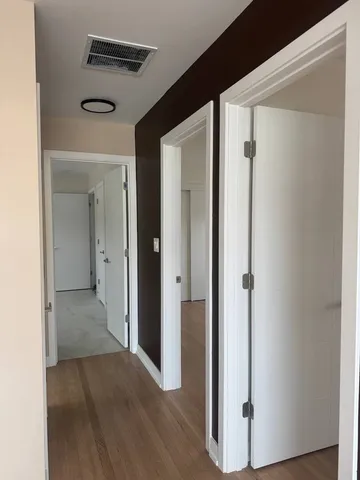 a view of a hallway with wooden floor
