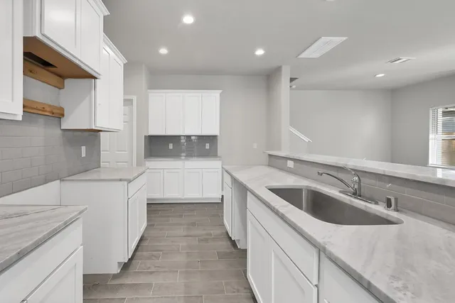 a kitchen with a sink stove and cabinets