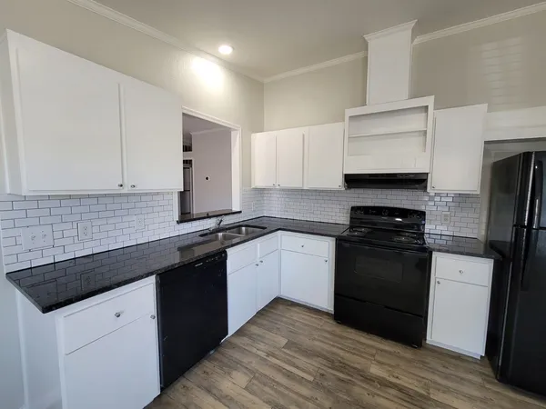 a kitchen with granite countertop a sink stove and refrigerator
