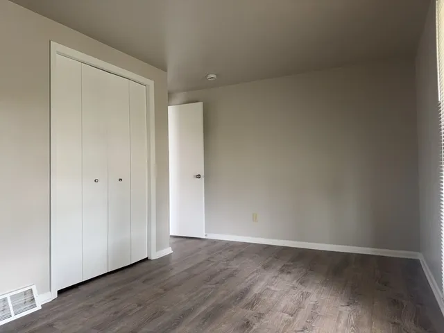 a view of an empty room with wooden floor