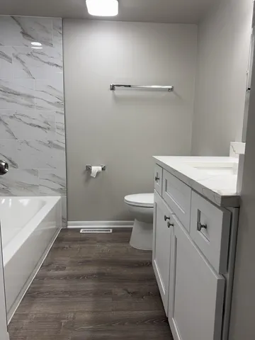 a bathroom with a granite countertop sink toilet and bathtub
