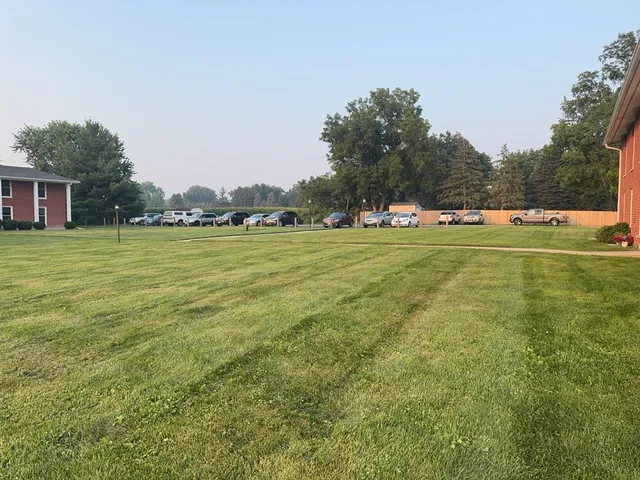 a yard with trees in the background
