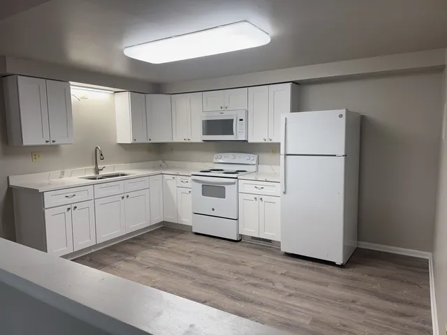 a kitchen with white cabinets and white appliances