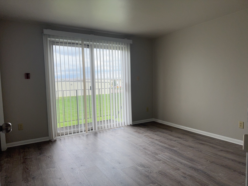 418 Beloit Street, Unit 6 Walworth, WI 53184 - Photo 8 of 23 a view of an empty room with wooden floor and a window