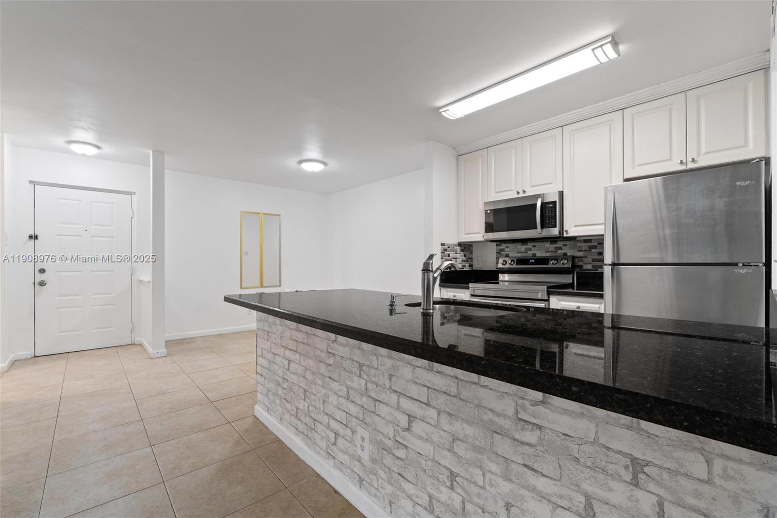 10421 Southwest 157th Place, Unit 206 Miami, FL 33196 - Photo 12 of 35 a kitchen with stainless steel appliances granite countertop a refrigerator and a stove top oven