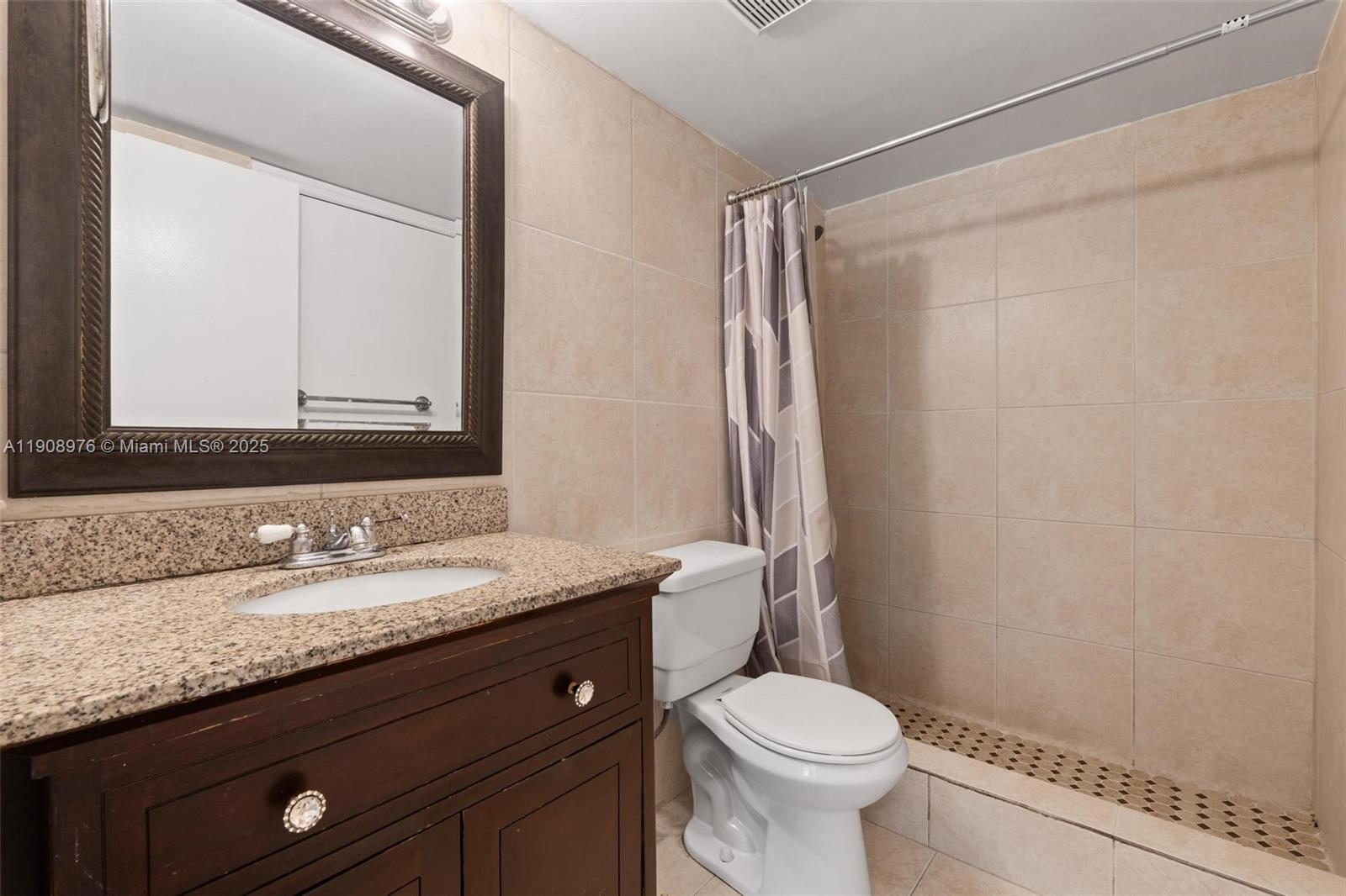 10421 Southwest 157th Place, Unit 206 Miami, FL 33196 - Photo 22 of 35 a bathroom with a granite countertop sink toilet and a mirror