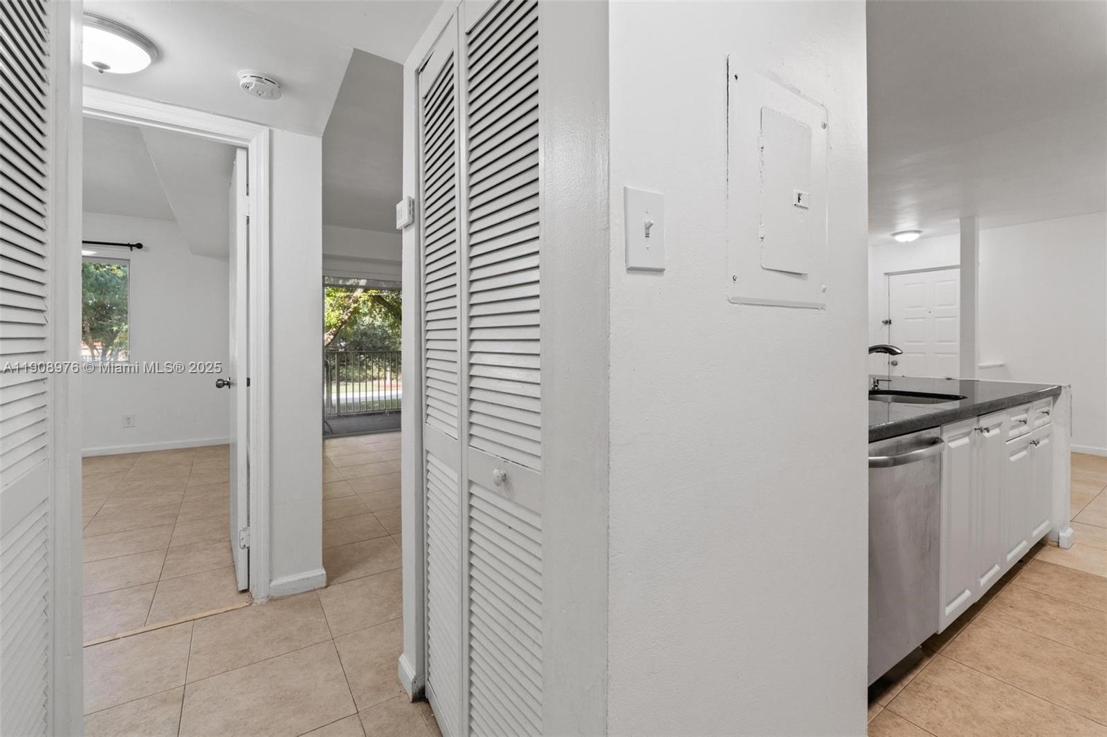 10421 Southwest 157th Place, Unit 206 Miami, FL 33196 - Photo 23 of 35 a kitchen with a refrigerator and white cabinets
