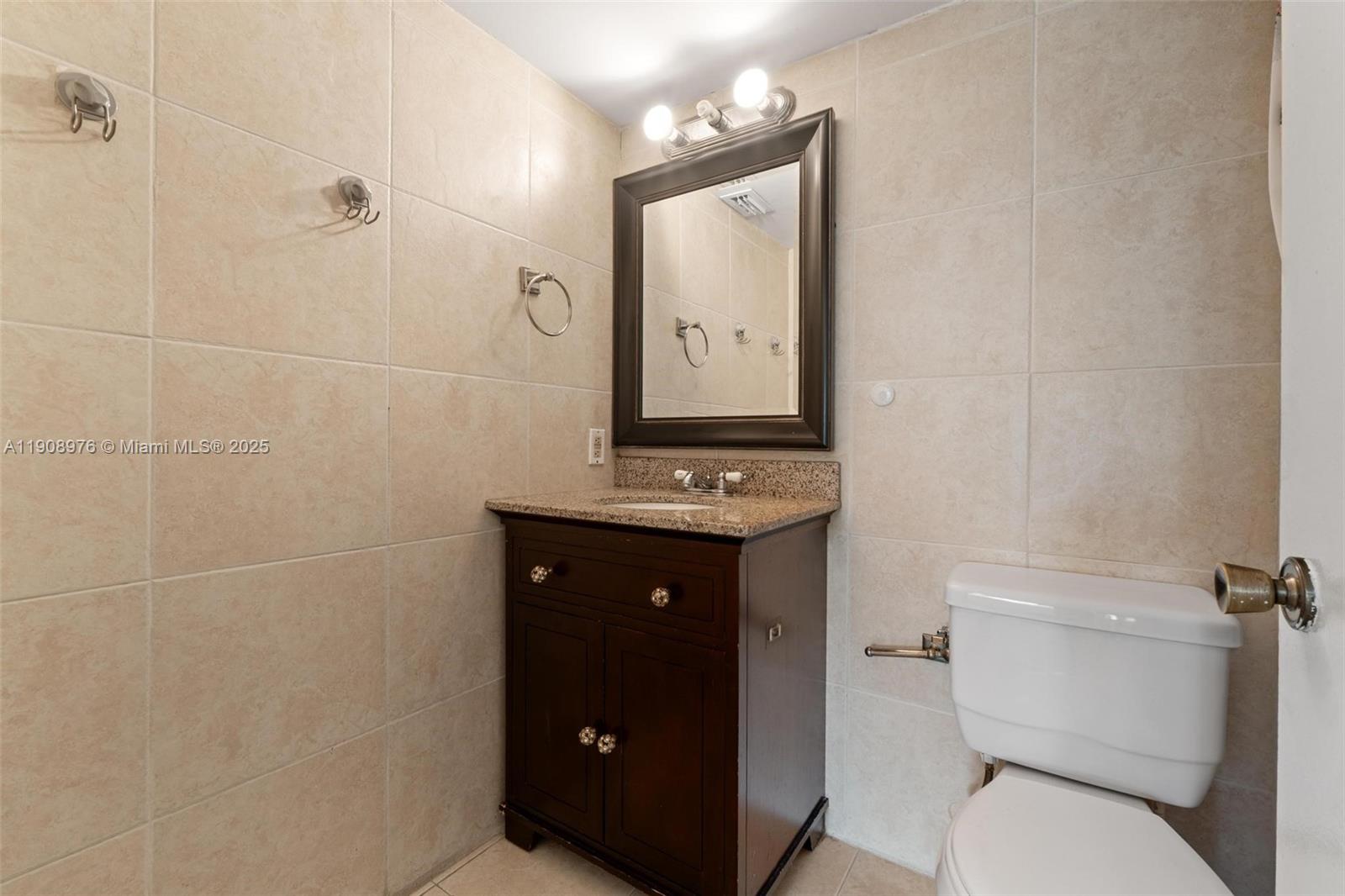 10421 Southwest 157th Place, Unit 206 Miami, FL 33196 - Photo 25 of 35 a bathroom with a toilet sink and mirror