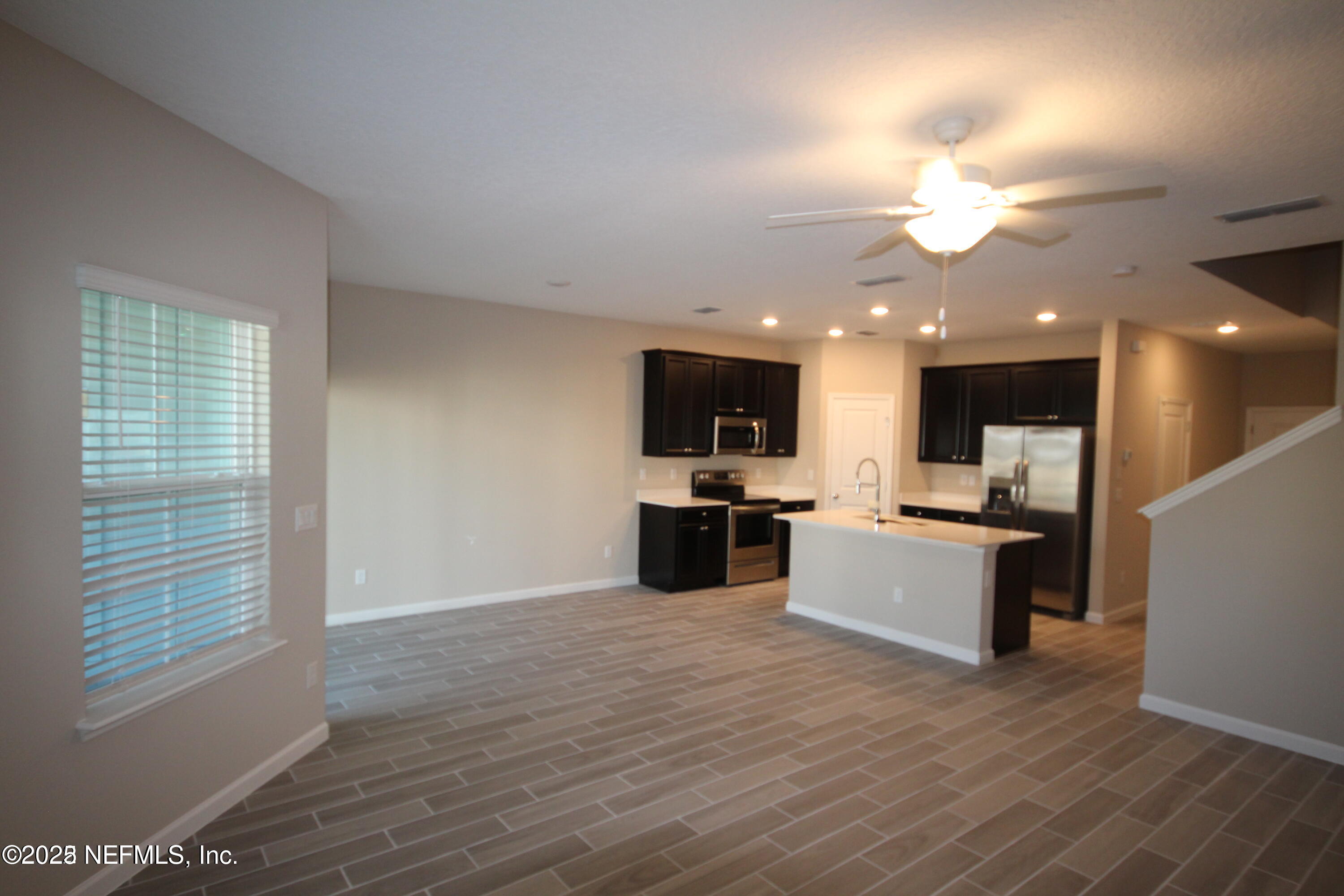 98 Boracay Circle St. Johns, FL 32259 - Photo 11 of 22 a view of a kitchen with kitchen island stainless steel appliances a sink dishwasher and a flat screen tv