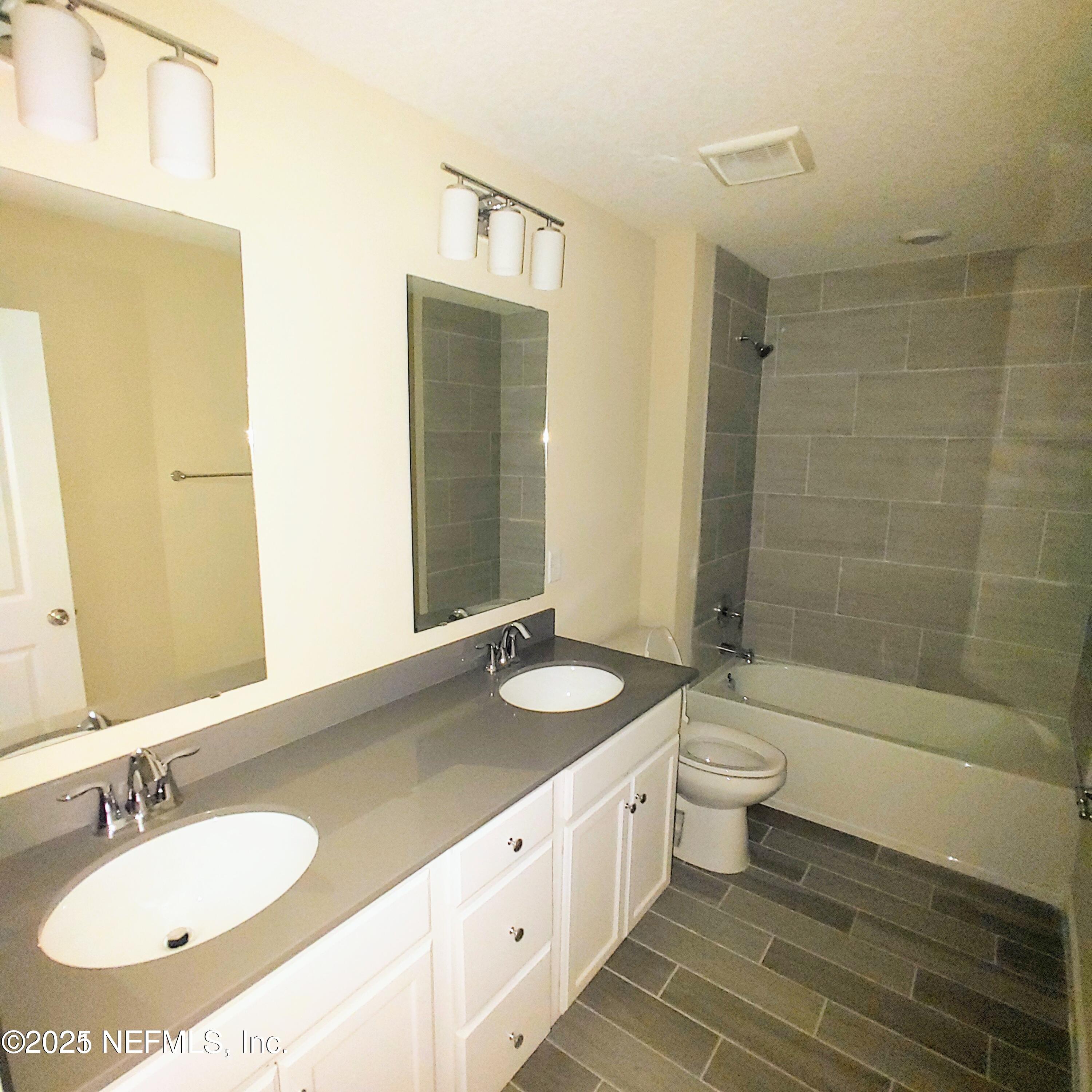 98 Boracay Circle St. Johns, FL 32259 - Photo 18 of 22 a bathroom with a granite countertop sink a toilet a mirror and shower
