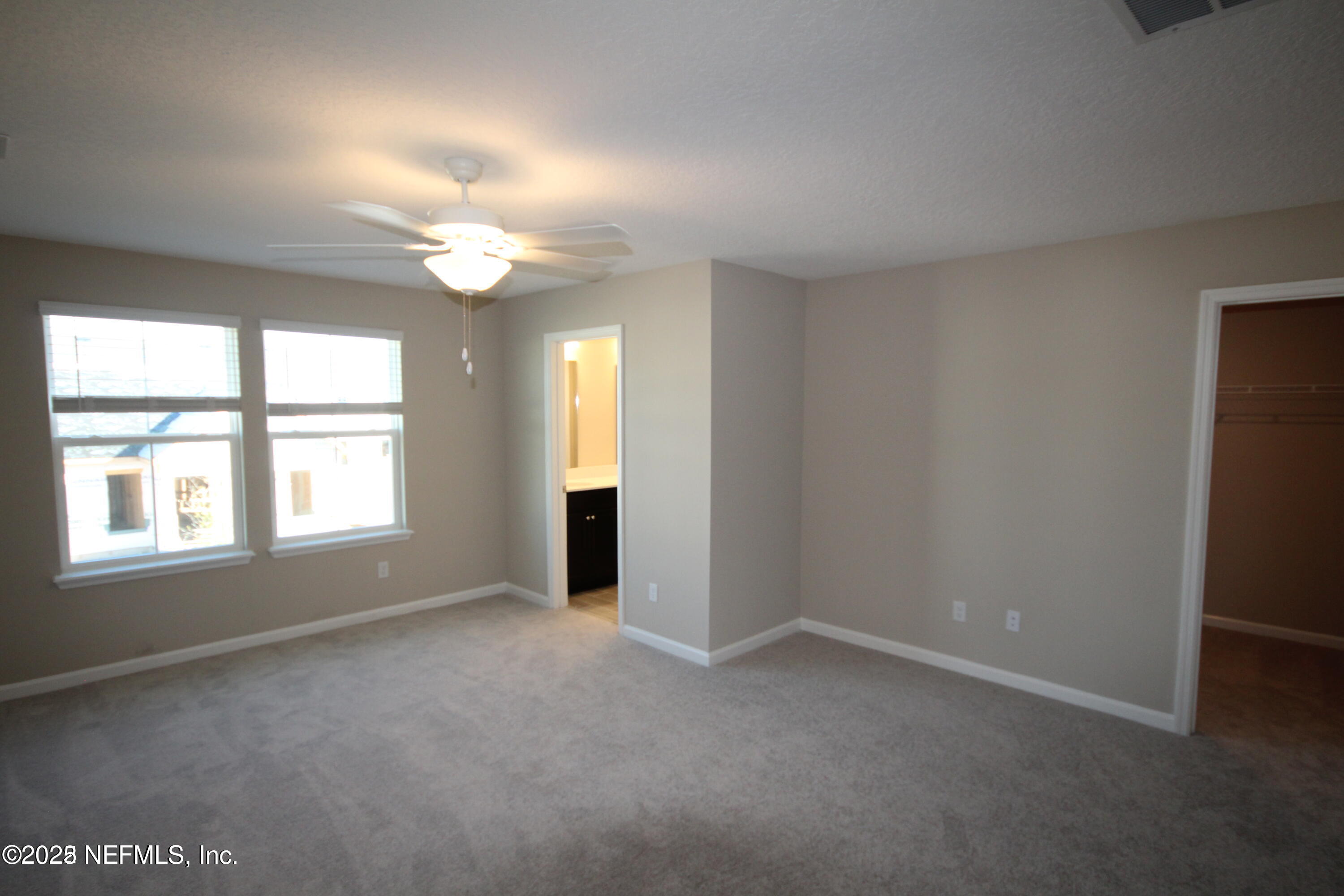 98 Boracay Circle St. Johns, FL 32259 - Photo 19 of 22 an empty room with windows and chandelier fan