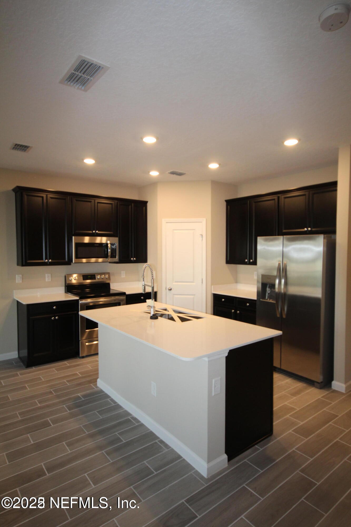 98 Boracay Circle St. Johns, FL 32259 - Photo 9 of 22 a large kitchen with stainless steel appliances kitchen island granite countertop a large counter top and a stove top oven