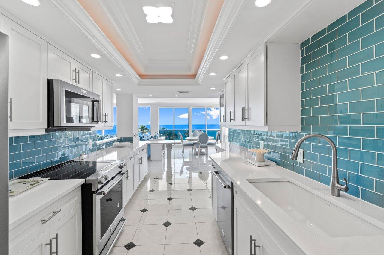 700 South Ocean Boulevard, Unit 405 Boca Raton, FL 33432 - Photo 11 of 59 a kitchen with stainless steel appliances a sink a stove a refrigerator cabinets and living room view