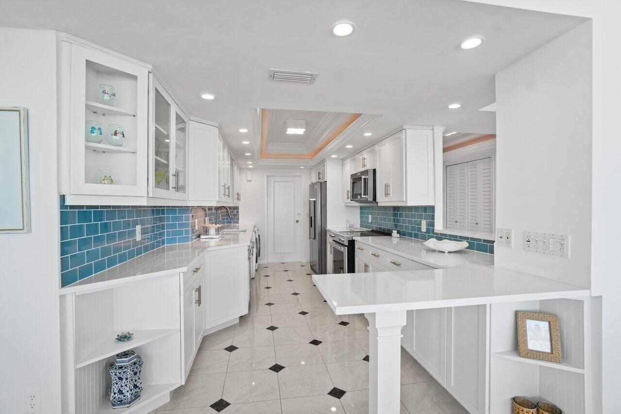 700 South Ocean Boulevard, Unit 405 Boca Raton, FL 33432 - Photo 16 of 59 a kitchen with stainless steel appliances kitchen island granite countertop a sink and cabinets