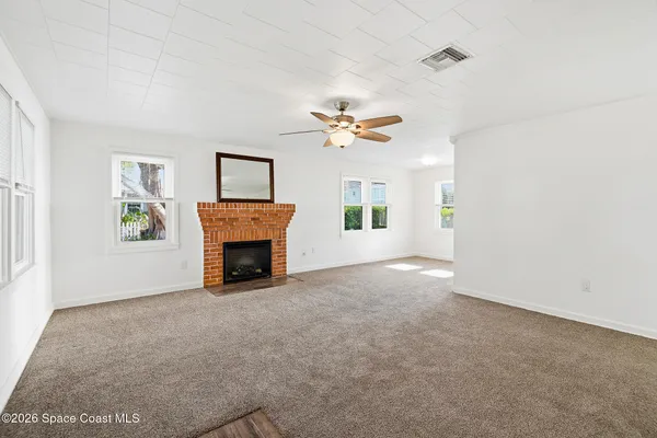a view of a livingroom with a fireplace and window