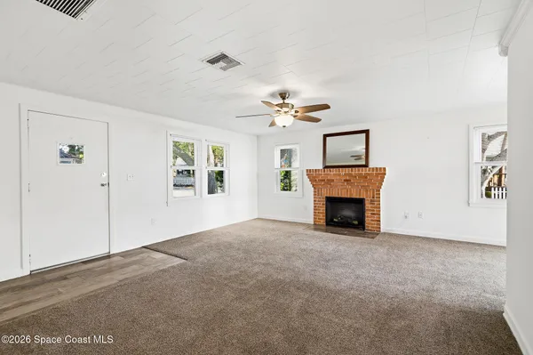 a view of a livingroom with a fireplace and window
