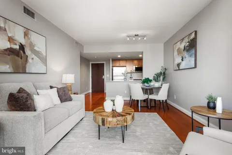 a living room with furniture and a wooden floor