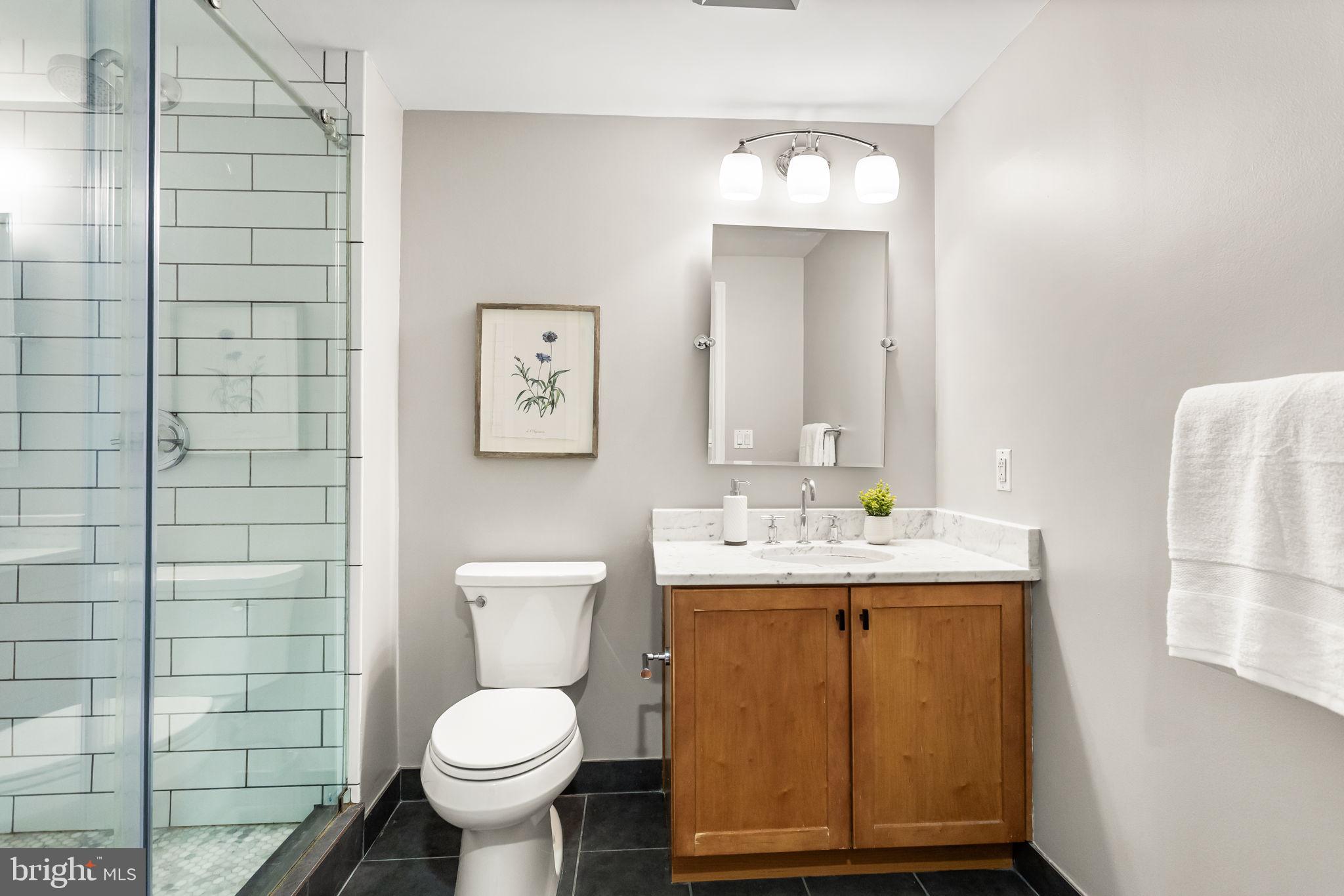 1020 North Highland Street, Unit 621 Arlington, VA 22201 - Photo 17 of 50 a bathroom with a granite countertop toilet and a sink