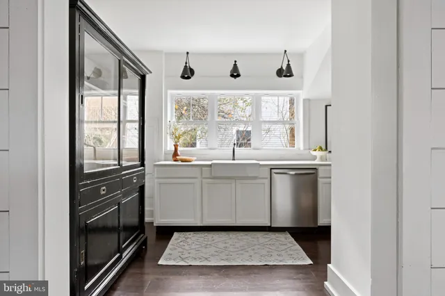 a kitchen with a refrigerator and white cabinets