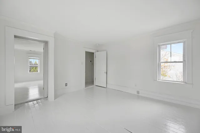 an empty room with windows and closet