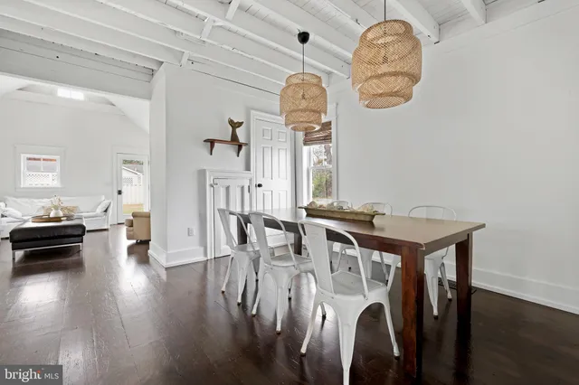 a view of a dining room with furniture a chandelier and wooden floor