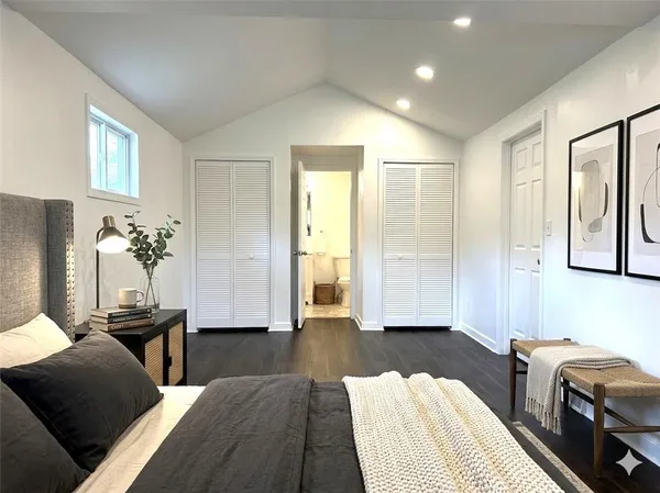 a view of a white house with a small yard and large tree