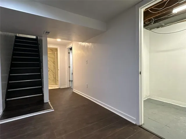 a view of an empty room with wooden floor and a cabinet