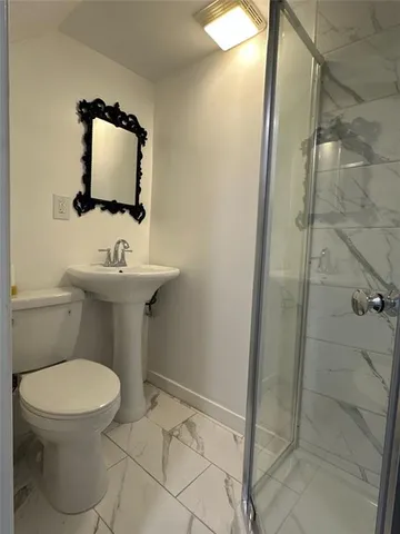 a bathroom with a toilet sink and shower