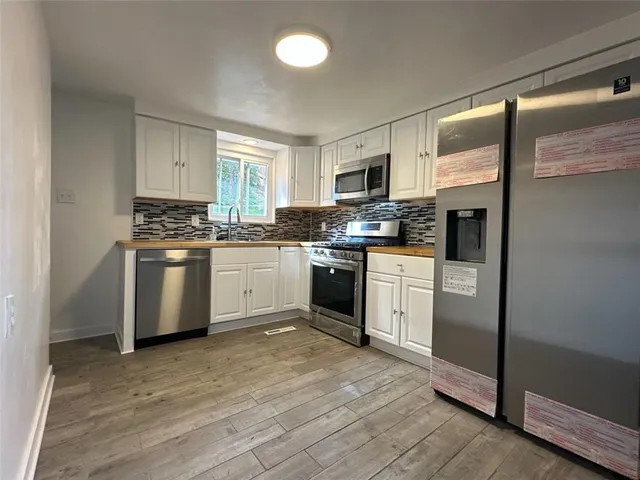 a kitchen with white cabinets stainless steel appliances and sink