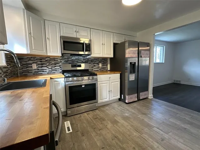 a kitchen with granite countertop a refrigerator stove and microwave
