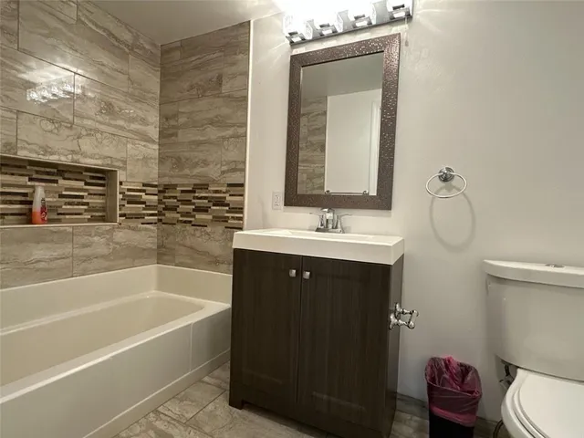 a bathroom with a sink a toilet and bathtub