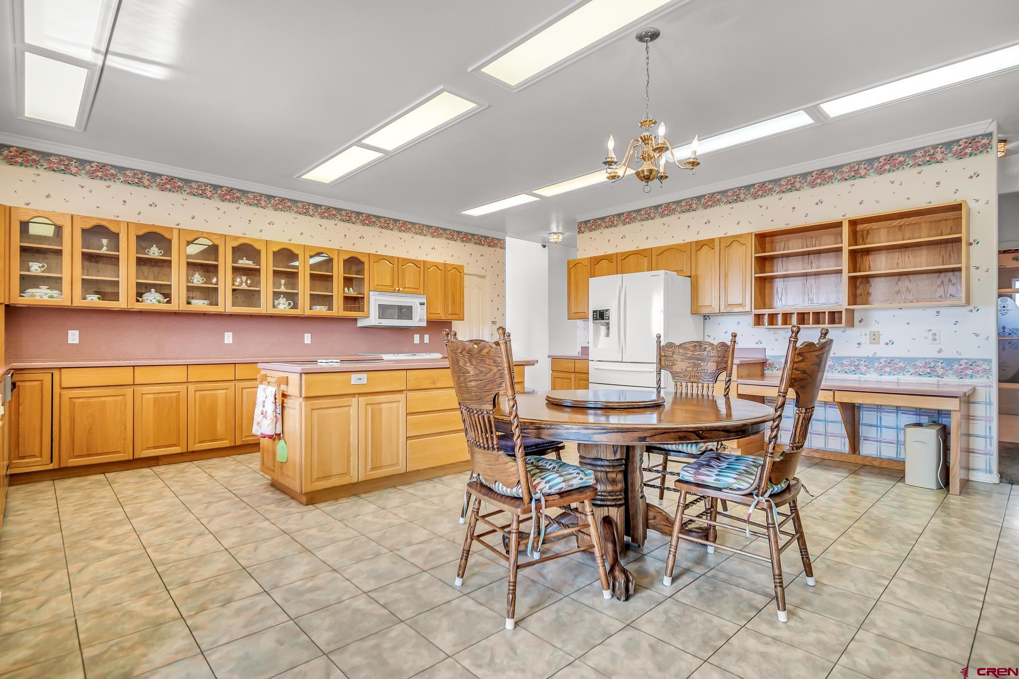 24344 Ute Trail Road Cedaredge, CO 81413 - Photo 14 of 33 a dining area with granite countertop a stove a table and chairs