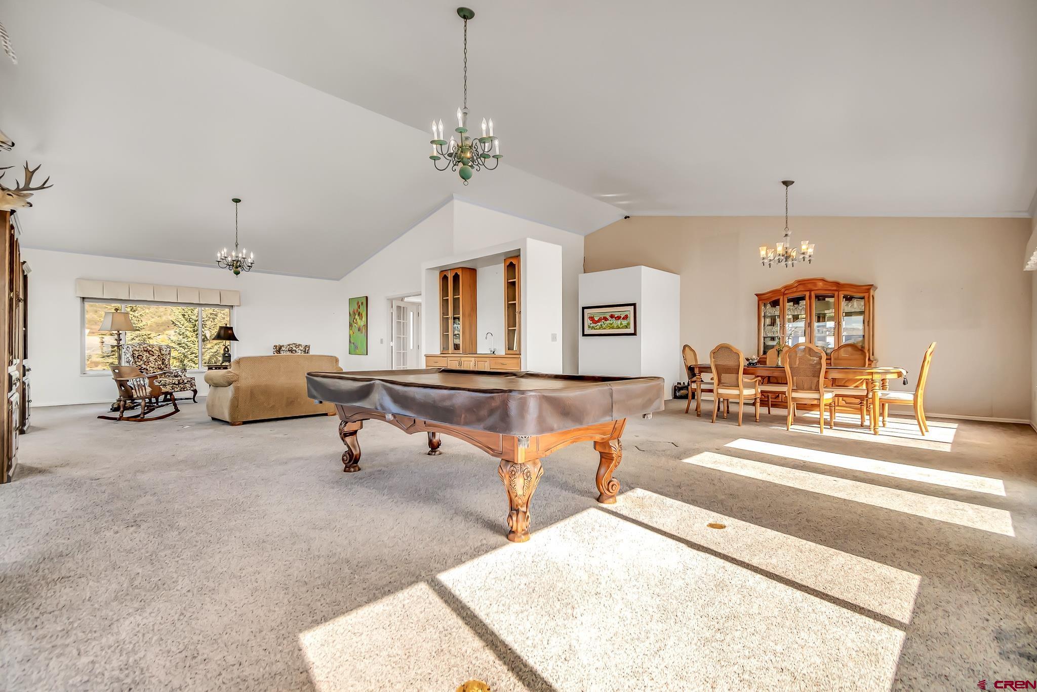 24344 Ute Trail Road Cedaredge, CO 81413 - Photo 19 of 33 a living room with furniture a chandelier and a dining table