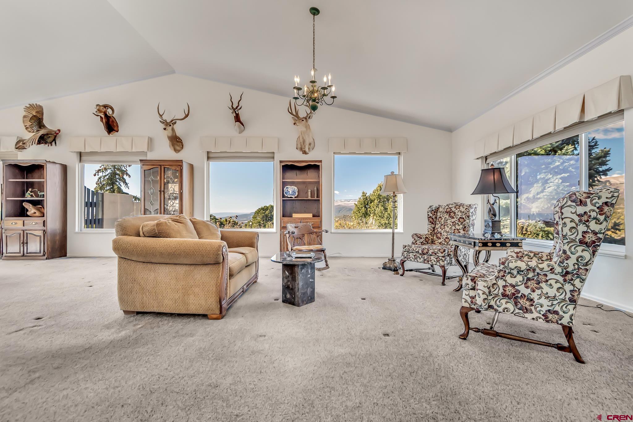 24344 Ute Trail Road Cedaredge, CO 81413 - Photo 22 of 33 a living room with furniture and a chandelier
