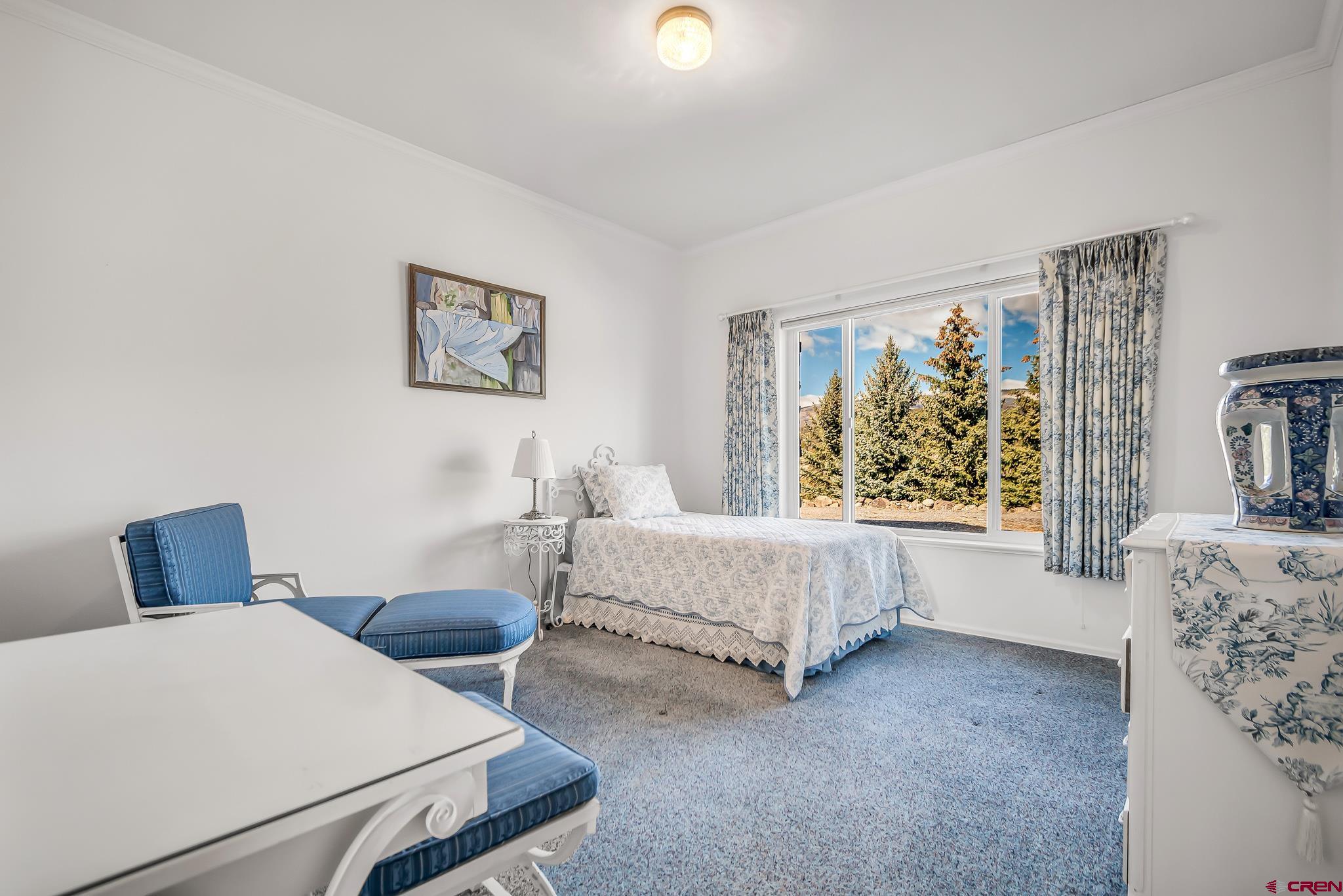 24344 Ute Trail Road Cedaredge, CO 81413 - Photo 27 of 33 a spacious bedroom with a bed and window