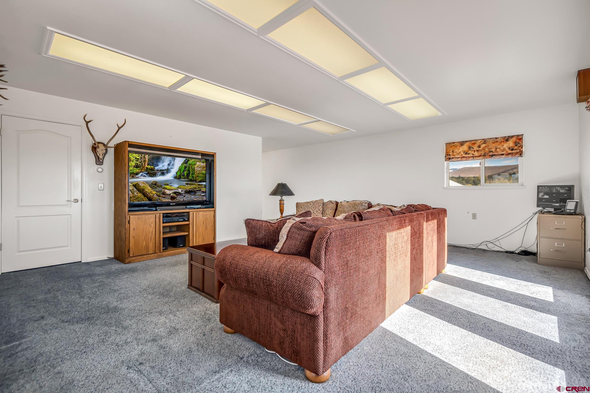 24344 Ute Trail Road Cedaredge, CO 81413 - Photo 31 of 33 a living room with furniture and a flat screen tv